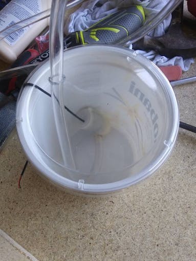 The pump inside the yogurt container with the aquarium tubing attached