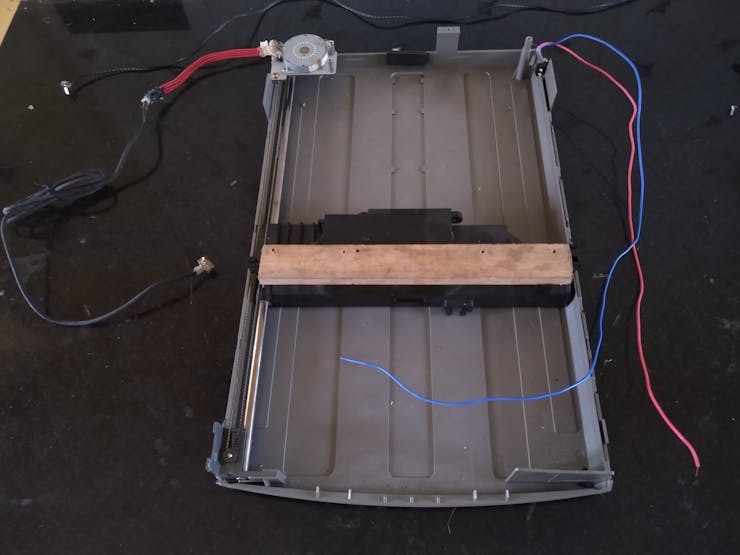The base with the scan head of an old flatbed scanner, with the stepper motor and limit switch attached.