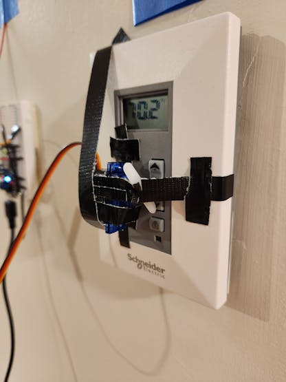 Servo motor pushing thermostat button and changing the temperature