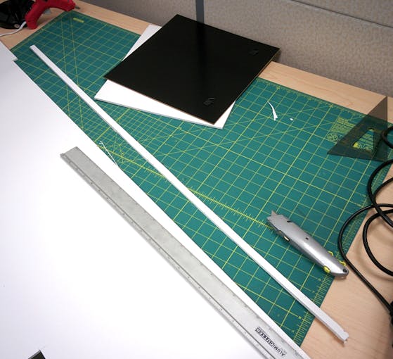 You can use the frame's back to help cut a 12" x 12" square.  Then cut a nice even 0.5" strip