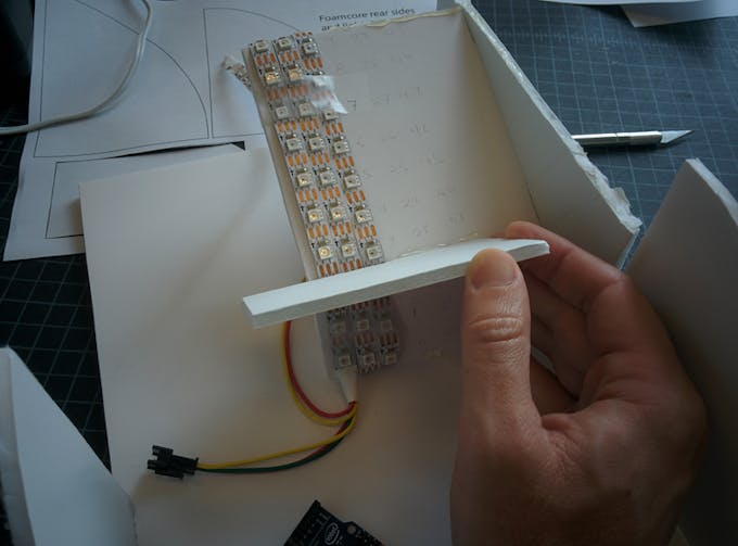 Add the largest light divider near the crease in the LED holder. Attach with hot glue and angle it forward as shown.
