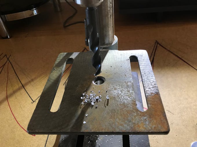 A pile of metal shavings on the drillpress after drilling the cap