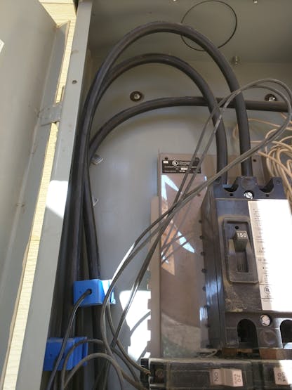 The blue sensors are clipped over the two hot leads before the main breaker