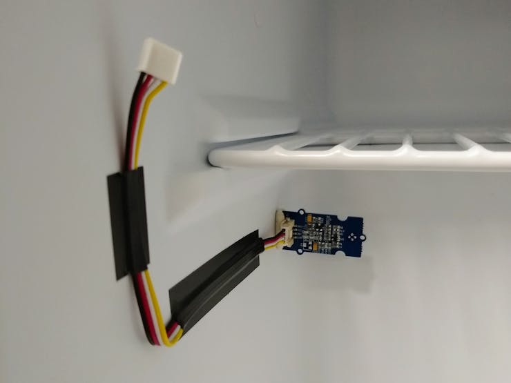 A temperature sensor attached to the inside of the fridge.