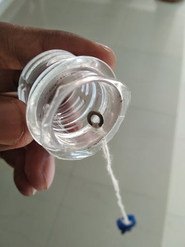 Looped thread attached to cap using a metal washer