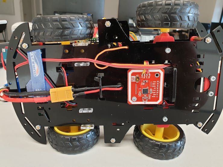 RFID scanner between the front wheels, centered to the vehicle