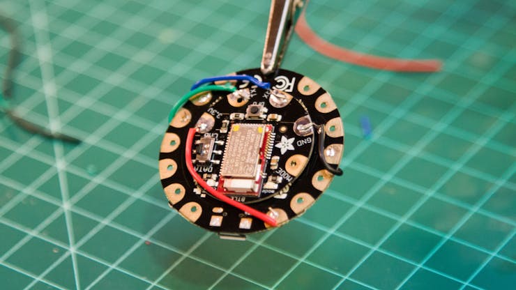 Solder to the appropriate pads (see Flora to Bluefruit wiring diagram in the Schematics section).