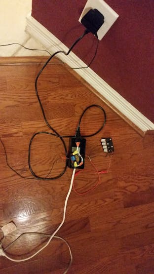 Inside of the box which houses the relay circuit, ESP8266, and the plug (both male and female). The 12 volt power supply for the relay is visible in the top center.